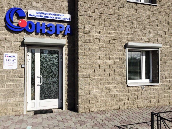 Вход в СОНЭРУ: белая дверь под синей вывеской на фасаде дома